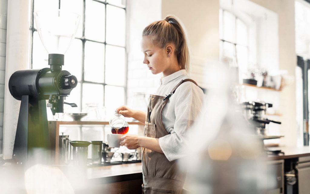 Barista making coffee at cafe counter