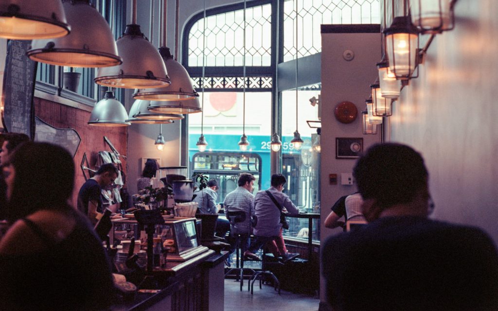 people enjoy coffee in a cafe where baristas use automation to prepare coffee